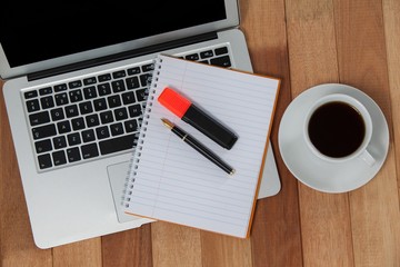 Cup of coffee with laptop, organizer, maker and pen