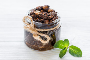 Body scrub of ground coffee on white table background