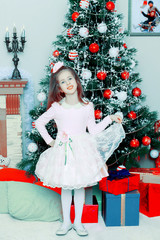 The little girl at the Christmas tree.