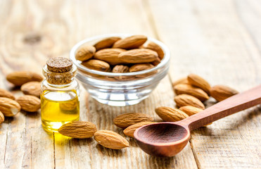 spa with almond oil in organic cosmetic set on wooden background