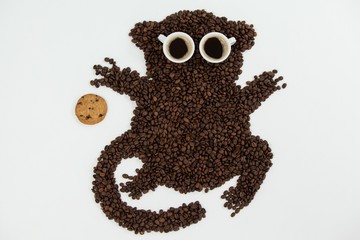 Coffee beans and cups forming monkey with cookie