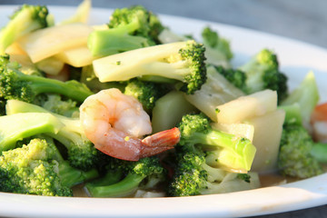 Thai food, stir-fried broccoli with shrimp on white plate.