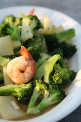 Thai food, stir-fried broccoli with shrimp on white plate.