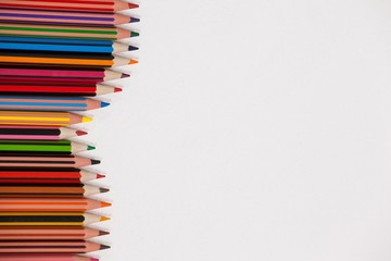 Close-up of colored pencils arranged in a wave pattern