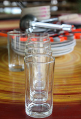 Row of empty water glass on wooden table.