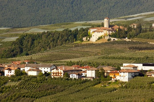 Castel Valer castle and the village in the apple trees valley, Val di Non, Italy