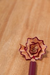 Close-up of maroon colored pencil with shavings