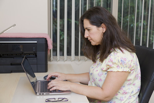 Female office worker typing on laptop