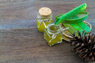Fresh aloe vera gel   with aloe  vera essential oil and pine  on wooden table