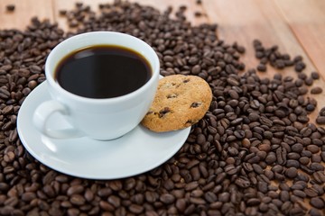 Coffee cup with cookie and coffee beans