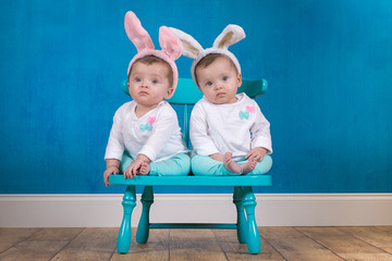 Adorable identical twin baby girls wearing bunny ears
