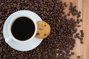 Coffee cup with cookie and coffee beans