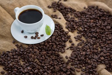 Black coffee, coffee beans and leaf on sack