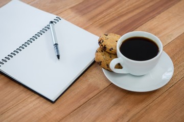 Open diary with pen and black coffee