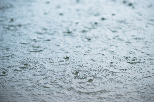 Raindrop on rippling water surface