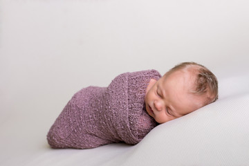 Beautiful newborn baby girl swaddled and sleeping