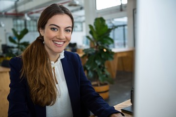 Smiling female executive working on computer