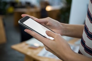 Mid section of female executive using mobile phone