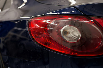 Tail light car with water drops. Exterior auto detail.