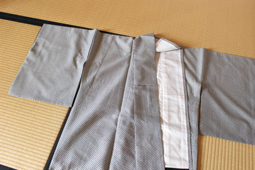畳の日本の和室でグレーの着物をしまっているところ
