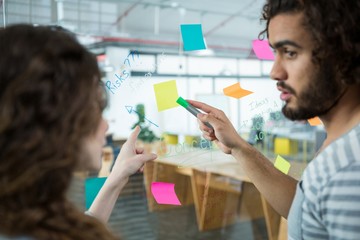Executives discussing over sticky notes