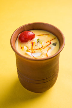 Authentic Indian cold drink made up of curd, milk & malai called Lassi in saffron / kesar flavour, also called kesariya or keshariya or kesar lassi, served in traditional indian terracotta glasses