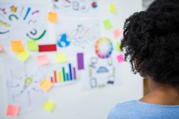 Female graphic designer looking at white board