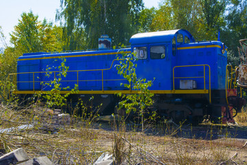 Old rusty locomotive in an abandoned factory in the industrial zone