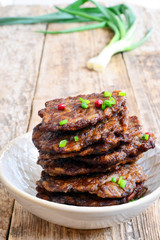 Fritters of liver.  Pancakes from the liver.  Food photo. Wooden background.