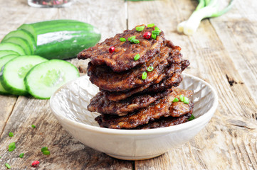 Fritters of liver.  Pancakes from the liver.  Food photo. Wooden background.