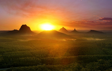 Mountains with setting sun and forest foreground, Queensland, Australia. - obrazy, fototapety, plakaty