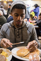 A young, hip man eats brunch at Brooklyn, NYC diner