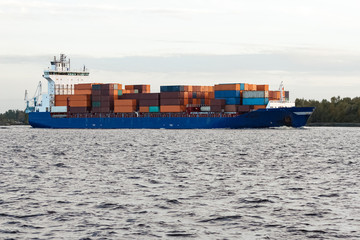 Blue container ship moving to Baltic sea. Riga, Latvia