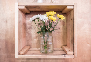 Flowers in vase with wooden box.