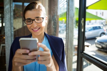 Female executive using mobile phone in café