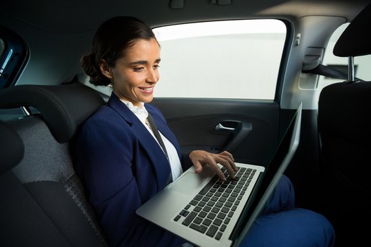 Business executive using laptop in car