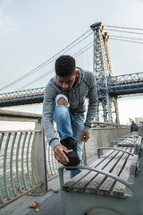 A portrait of a young, black man along NYC's East River Williamsburg Bridge