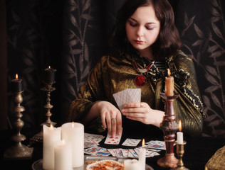 Young woman with divination cards in room