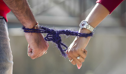 Lovers hands in jute rope handcuffs