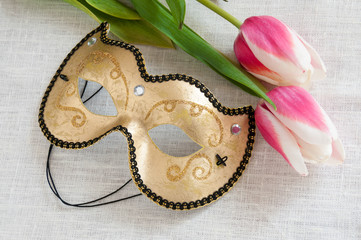 Red and white tulips golden mask on white linen fabric