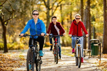 Healthy lifestyle - people riding bicycles in city park