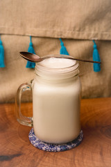 A glass of traditional Turkish cold drink ayran made of yoghurt on vintage background 