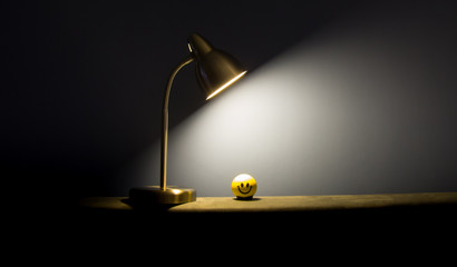 Single lamp illuminating a stress ball in the dark.