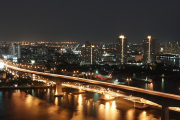 Fototapeta na wymiar night picture of car crossing bridge in Bangkok over Chao Phraya River with slow shutter speed 