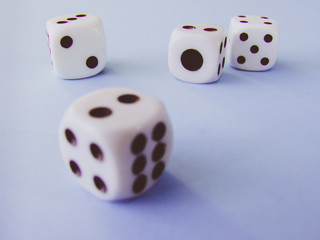 White cubic dices lying on a violet background.