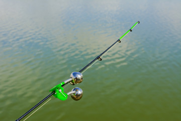 Lake in the mountains. Early morning. Fishing rod with a bell