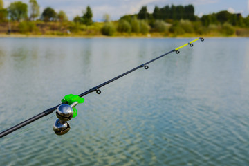 Lake in the mountains. Early morning. Fishing rod with a bell