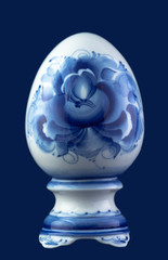 Ceramic egg with floral pattern isolated on blue 