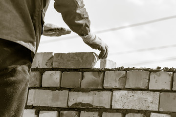 Worker builds a brick wall in the house