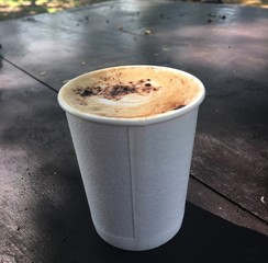 paper cup of hot coffee on the wooden table